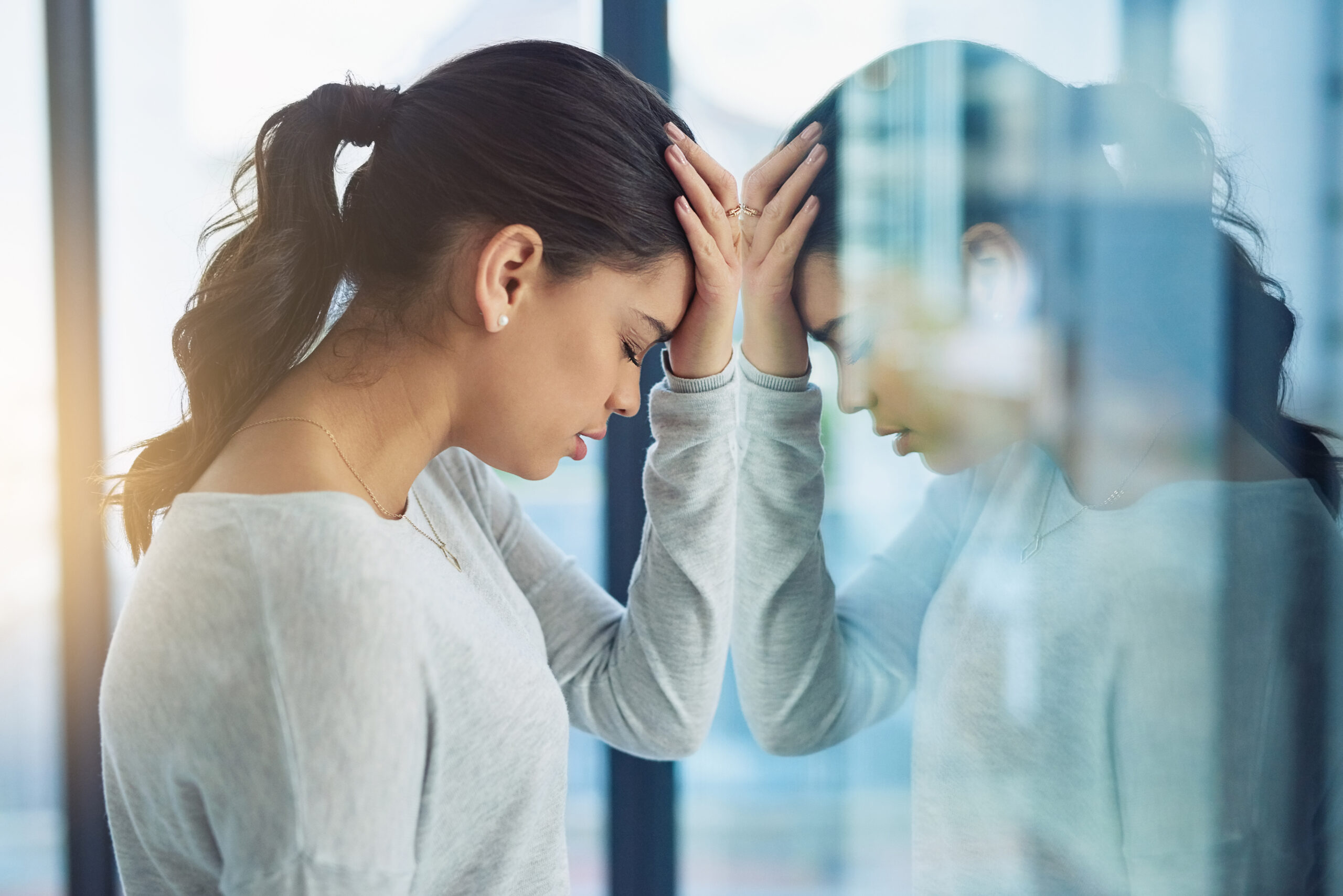 Shot of a young businesswoman looking stressed out in an office.